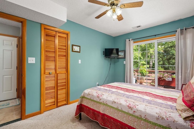 carpeted bedroom with a closet, visible vents, a ceiling fan, a textured ceiling, and baseboards