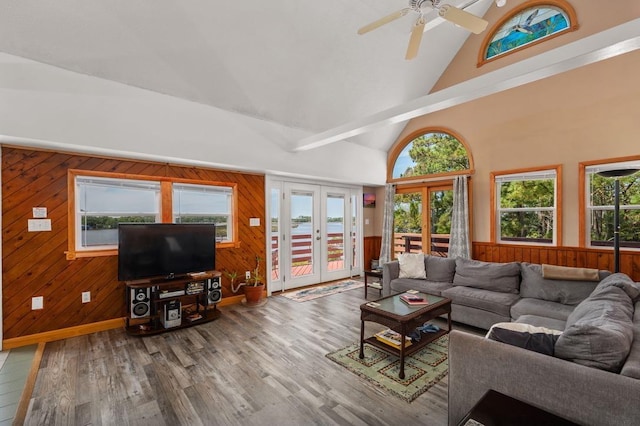 living room featuring high vaulted ceiling, a wealth of natural light, french doors, and wood finished floors