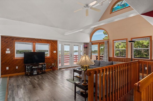 living room with french doors, a healthy amount of sunlight, wood walls, and wood finished floors