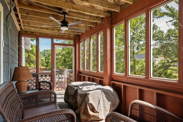 sunroom featuring ceiling fan, wood ceiling, beam ceiling, and a healthy amount of sunlight