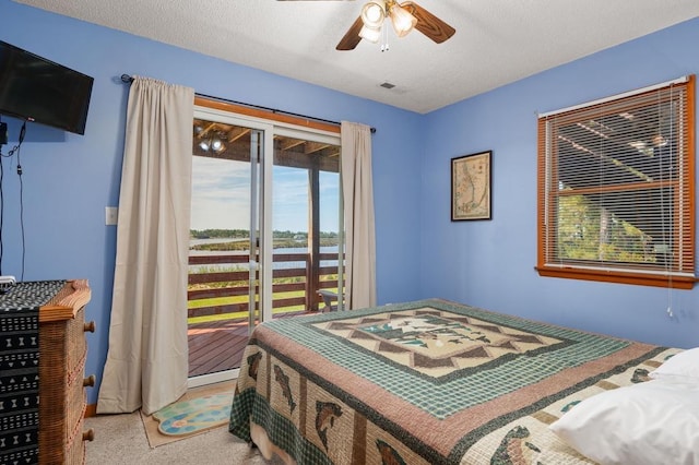 bedroom with a textured ceiling, access to outside, a ceiling fan, and light colored carpet