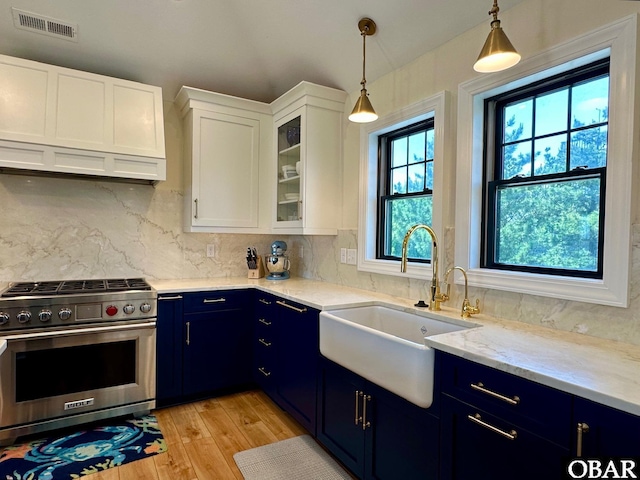 126 Buffell Head Rd Lot 146, Duck, NC 27949 - kitchen with blue cabinetry, high end range, a sink, light wood finished floors, and decorative backsplash