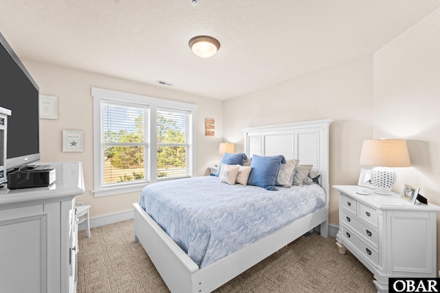 bedroom featuring baseboards, visible vents, and light colored carpet