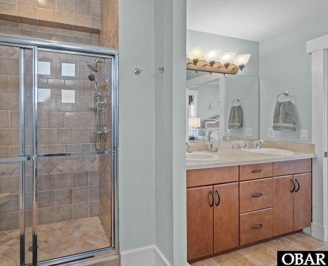 full bath featuring double vanity, a sink, and a shower stall