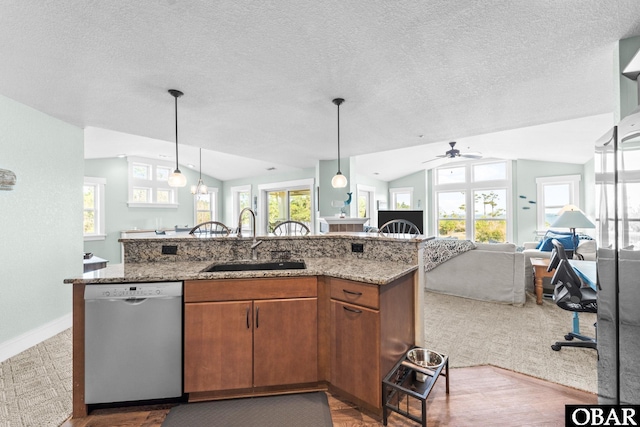 kitchen with lofted ceiling, a sink, open floor plan, hanging light fixtures, and stainless steel dishwasher