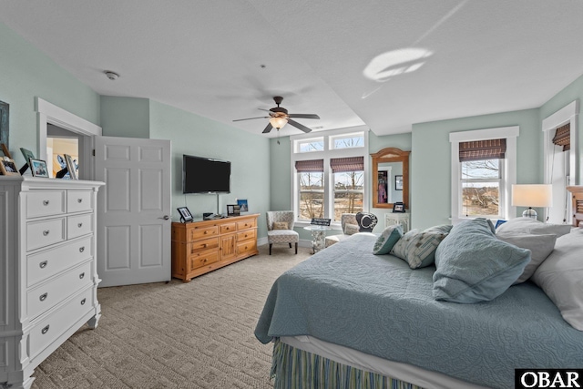 bedroom with light colored carpet, ceiling fan, and baseboards