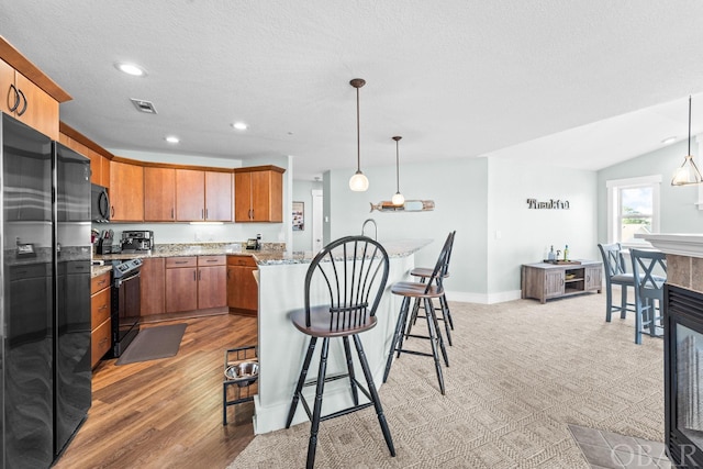 kitchen featuring pendant lighting, visible vents, baseboards, and black appliances