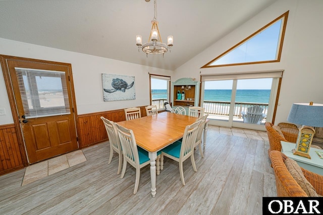 24143 Ocean Dr Lot 4, Rodanthe, NC 27968 - dining space with a chandelier, a wainscoted wall, light wood-style floors, healthy amount of natural light, and wooden walls