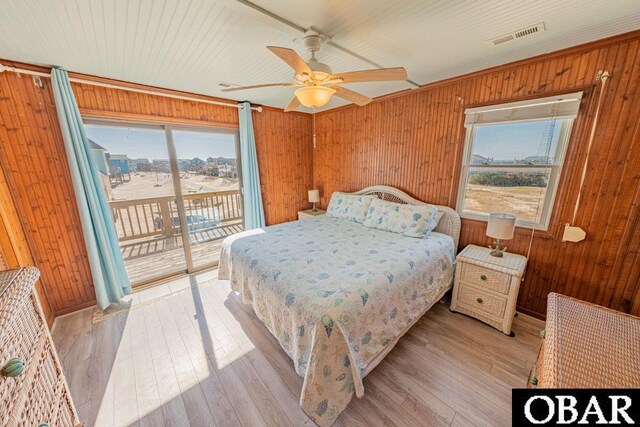 24143 Ocean Dr Lot 4, Rodanthe, NC 27968 - bedroom with multiple windows, wood walls, access to outside, hardwood / wood-style floors, and a ceiling fan