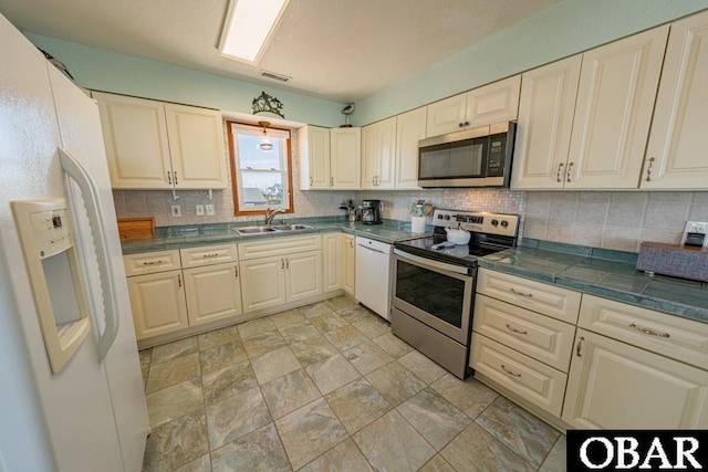 24143 Ocean Dr Lot 4, Rodanthe, NC 27968 - kitchen with appliances with stainless steel finishes, a sink, tasteful backsplash, dark countertops, and light stone finish flooring