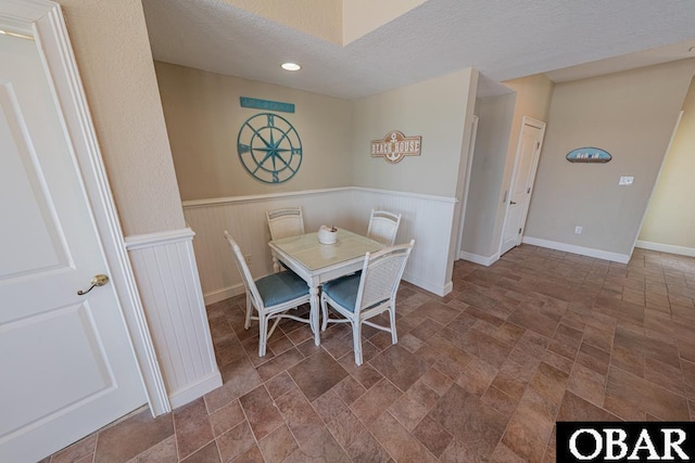 22097 Sea Gull St Lot 7, Rodanthe, NC 27968 - dining area with stone finish floors, wainscoting, a textured ceiling, recessed lighting, and baseboards