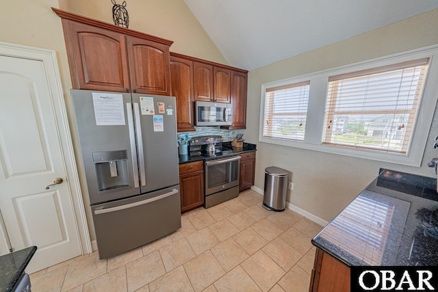22097 Sea Gull St Lot 7, Rodanthe, NC 27968 - kitchen featuring appliances with stainless steel finishes, vaulted ceiling, decorative backsplash, brown cabinets, and baseboards
