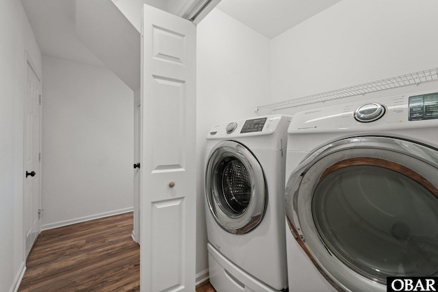 clothes washing area featuring laundry area, washing machine and dryer, baseboards, and dark wood-style flooring