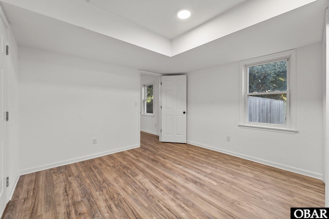 spare room with light wood finished floors, baseboards, and recessed lighting