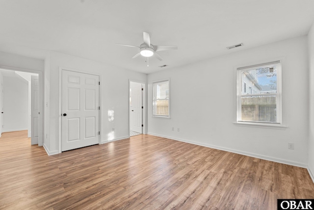 unfurnished bedroom with light wood-style floors, baseboards, multiple windows, and visible vents