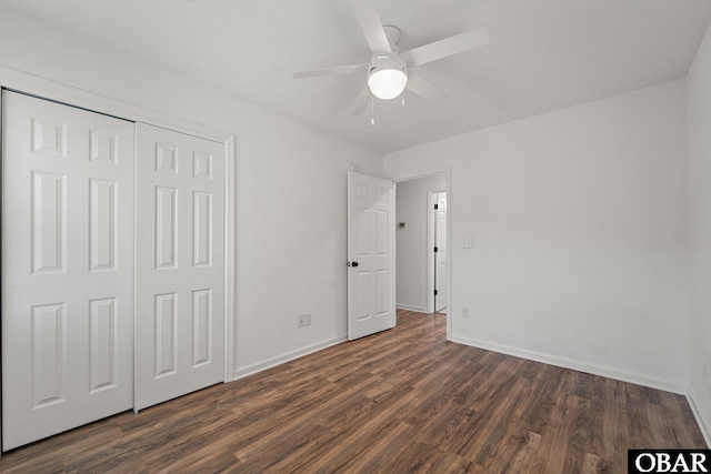 unfurnished bedroom featuring a closet, dark wood-style flooring, baseboards, and a ceiling fan