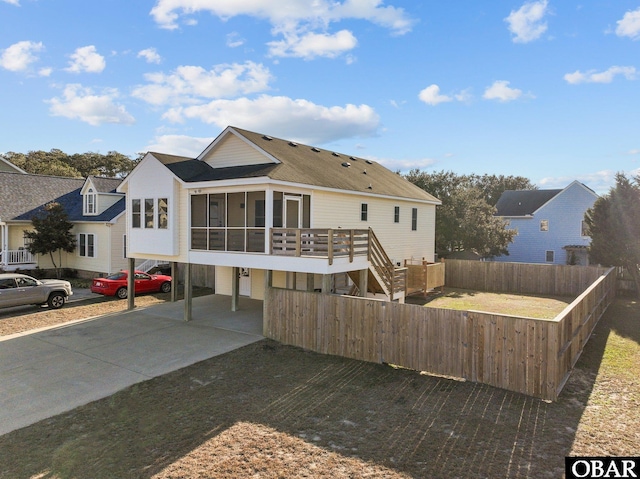 view of front of house featuring a sunroom, stairs, fence, and a residential view