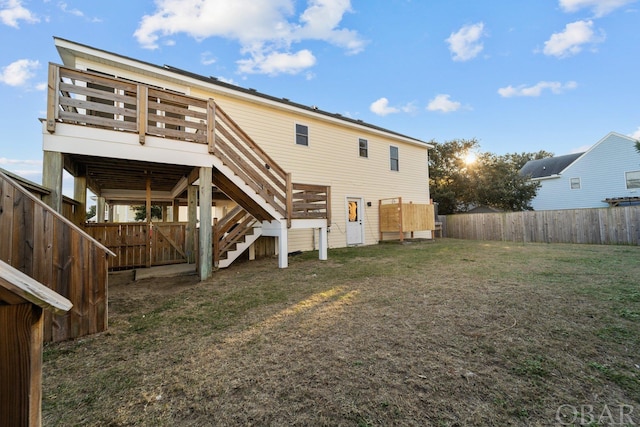 back of property with stairway, fence, and a yard