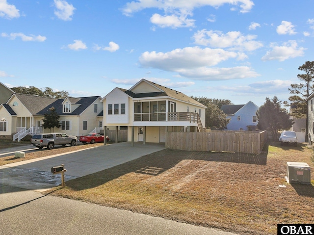 view of front of home featuring a sunroom, a residential view, and fence