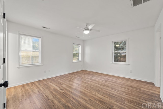 unfurnished room with visible vents, baseboards, and wood finished floors