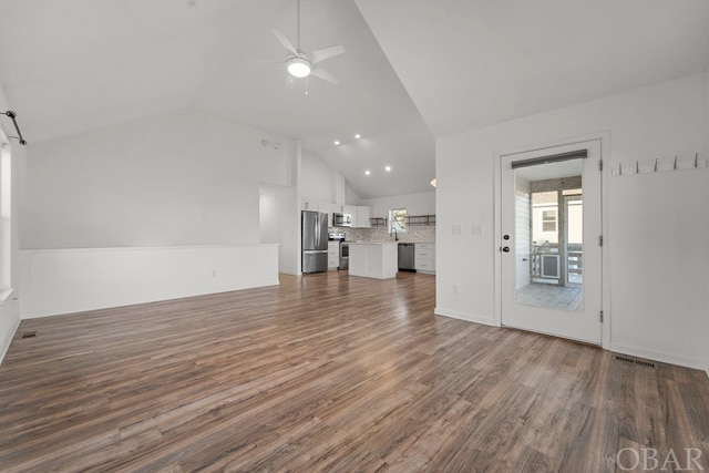 unfurnished living room featuring lofted ceiling, ceiling fan, and dark wood-type flooring