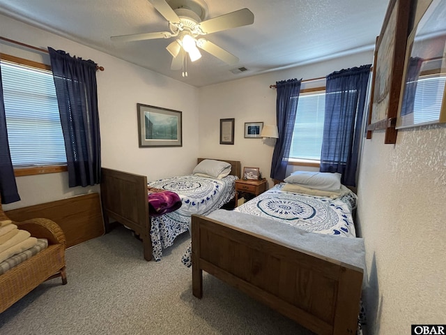 carpeted bedroom with visible vents and ceiling fan