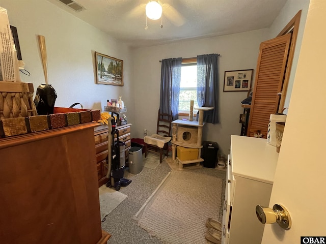 home office with visible vents, ceiling fan, and light colored carpet