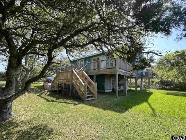 rear view of property with a yard, a wooden deck, and stairway