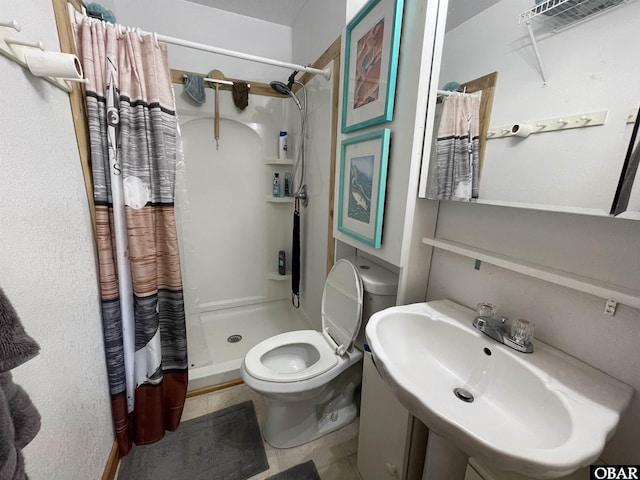 full bathroom with a shower stall, tile patterned flooring, a sink, and toilet