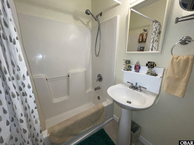 bathroom with shower / bath combo with shower curtain and baseboards