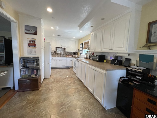 kitchen with tasteful backsplash, recessed lighting, white appliances, white cabinetry, and a sink