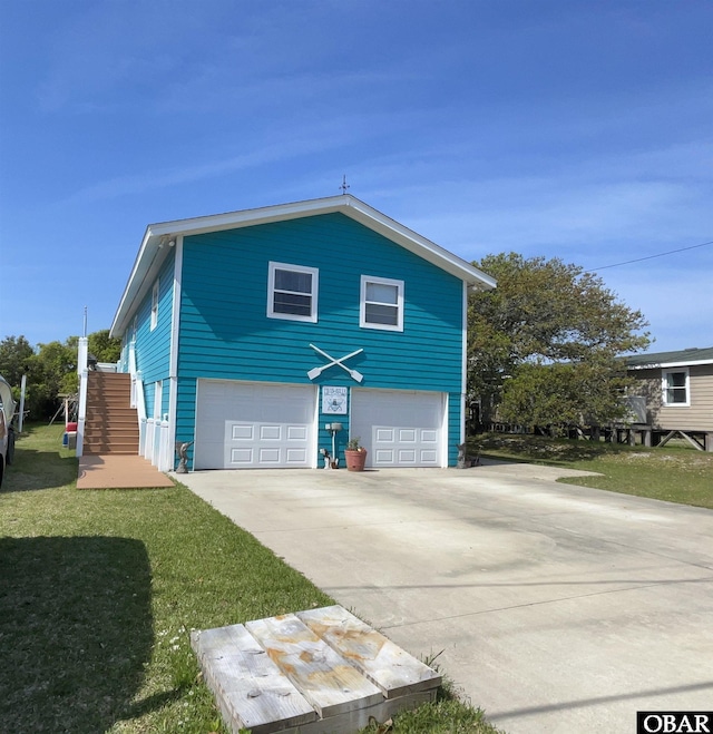 view of side of property with a garage, a yard, and concrete driveway