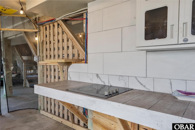 23014 Cross Of Honor Way Lot 20, Rodanthe, NC 27968 - detailed view of black electric cooktop, concrete flooring, backsplash, and white cabinets