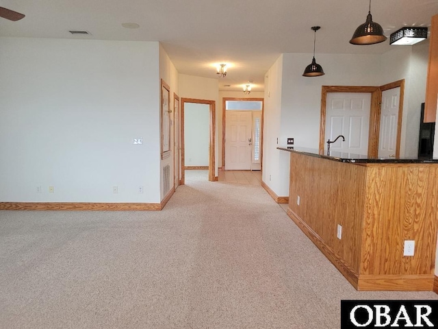 interior space with light carpet, baseboards, visible vents, and a sink