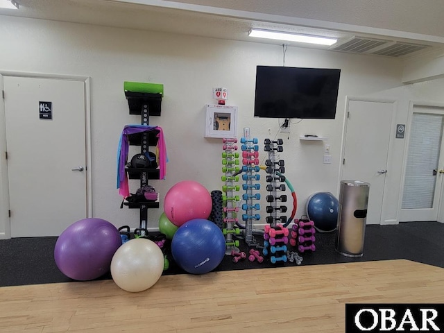 workout room with visible vents and wood finished floors