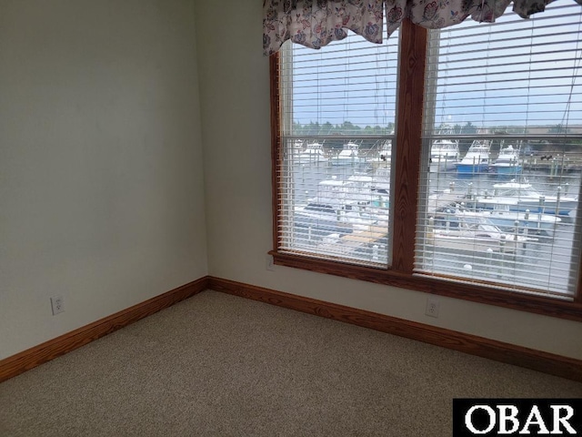unfurnished room with carpet flooring and baseboards