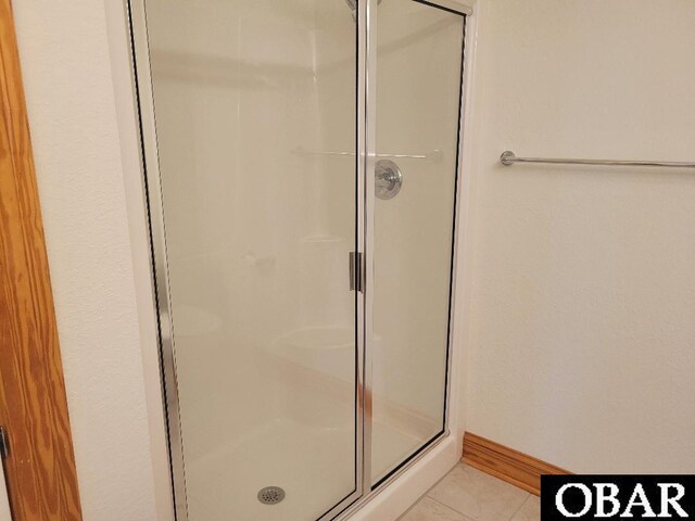 full bathroom featuring baseboards and a shower stall