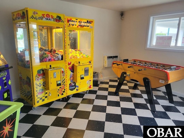 rec room with baseboards, tile patterned floors, and a wall unit AC