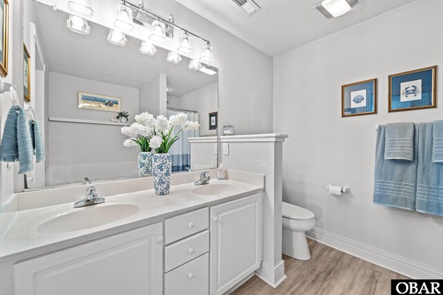 bedroom featuring baseboards, ceiling fan, visible vents, and wood finished floors