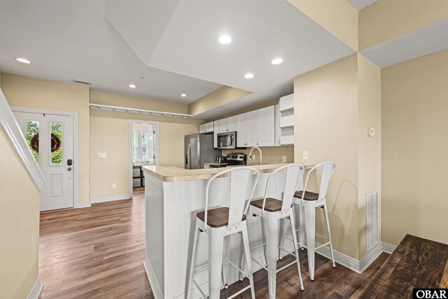 1108 Cambridge Rd Unit 307-A, Kill Devil Hills, NC 27948 - kitchen with stainless steel appliances, a peninsula, wood finished floors, light countertops, and recessed lighting