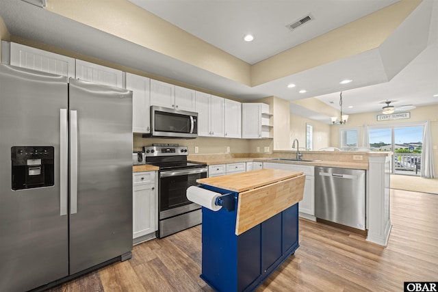 1108 Cambridge Rd Unit 307-A, Kill Devil Hills, NC 27948 - kitchen featuring stainless steel appliances, a peninsula, wooden counters, light wood finished floors, and recessed lighting