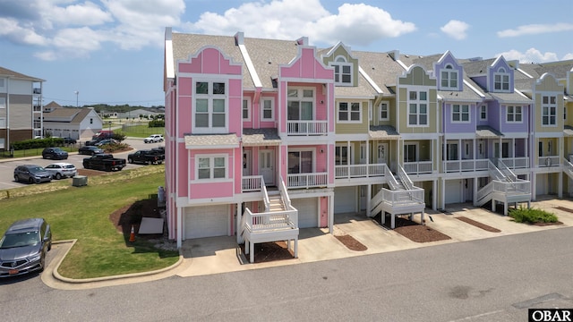 1108 Cambridge Rd Unit 307-A, Kill Devil Hills, NC 27948 - view of front of property featuring a residential view, an attached garage, a shingled roof, and driveway