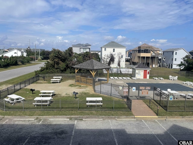 surrounding community with a gazebo, a fenced front yard, and a residential view