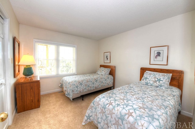 bedroom featuring baseboards, a textured ceiling, and light colored carpet