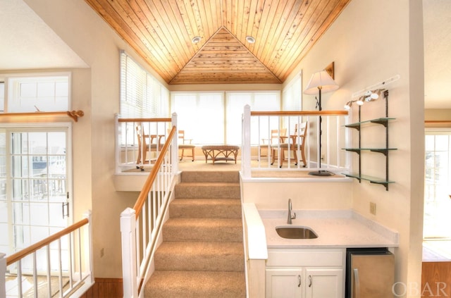 staircase with wooden ceiling, vaulted ceiling, and crown molding