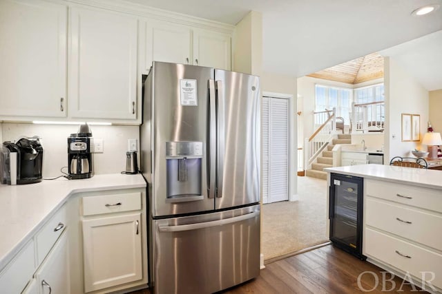 kitchen with wine cooler, white cabinets, light countertops, and stainless steel fridge with ice dispenser