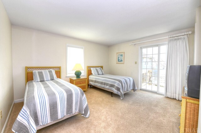 bedroom featuring access to exterior, baseboards, and light colored carpet