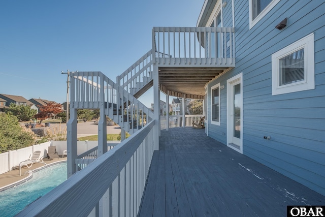 wooden terrace with stairway and a fenced in pool