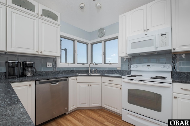 kitchen featuring white cabinetry, a sink, light wood-type flooring, white appliances, and backsplash