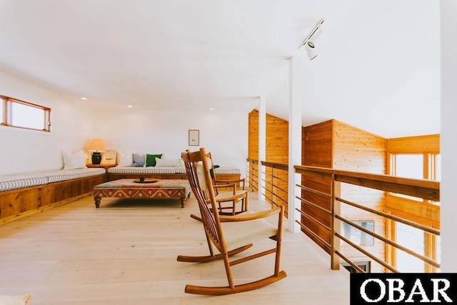 sitting room with recessed lighting, wooden walls, light wood-type flooring, and rail lighting